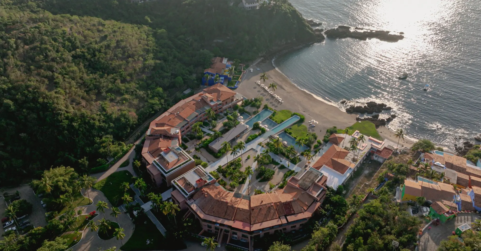 Aerial view of El Careyes Club & Residences between the beach and the jungle-covered hills