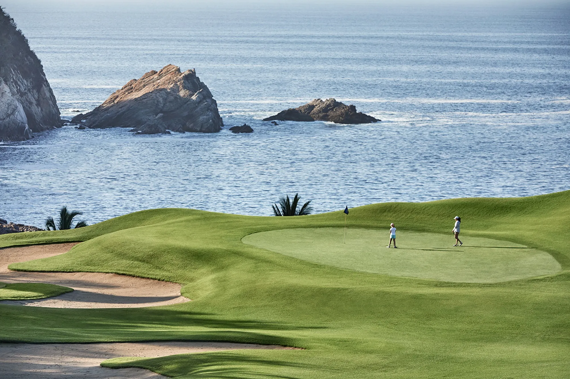 Golfers on a green above the Pacific at Tamarindo